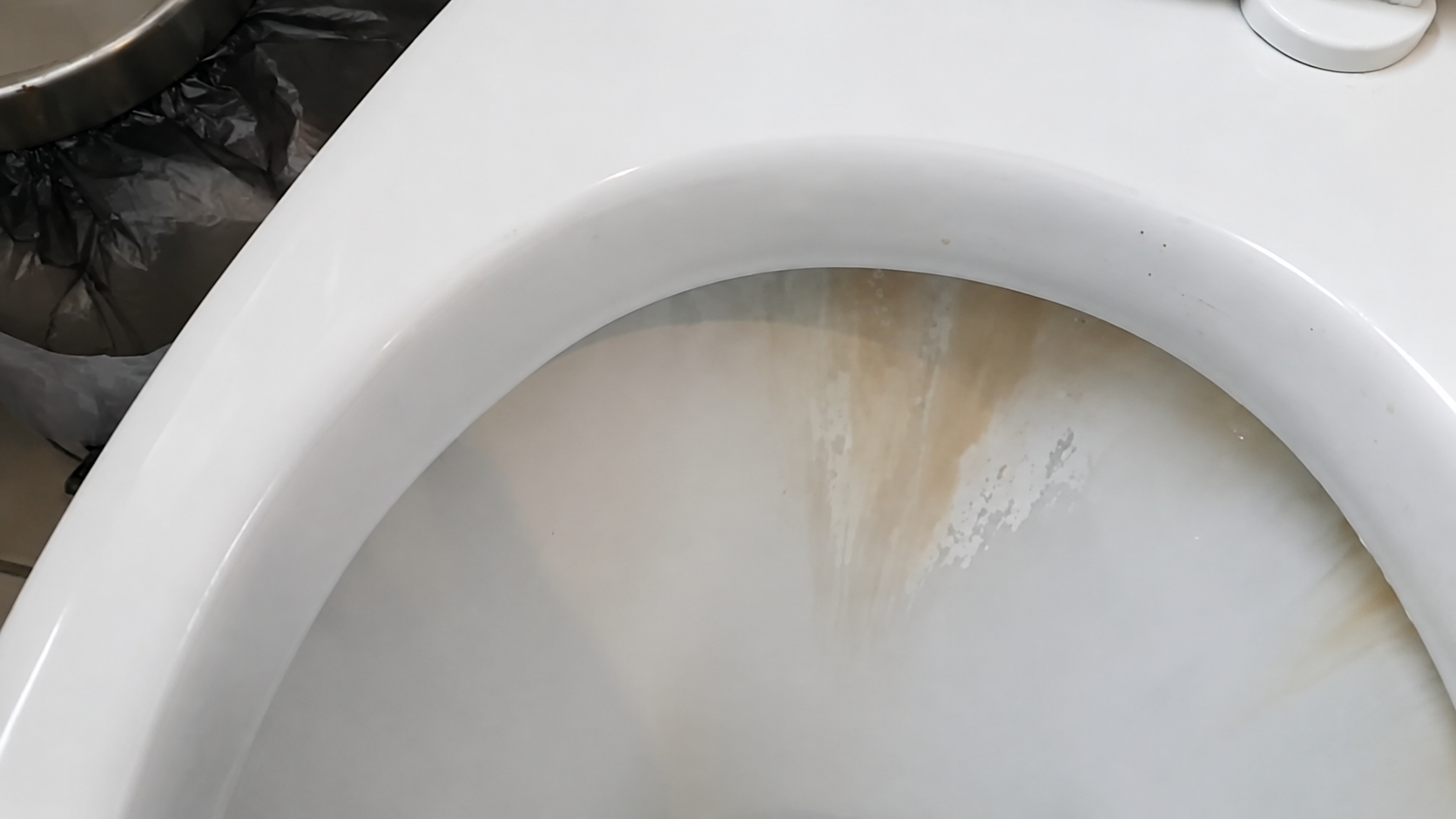 Toilettenbecken vor der Grundreinigung mit sichtbaren Ablagerungen